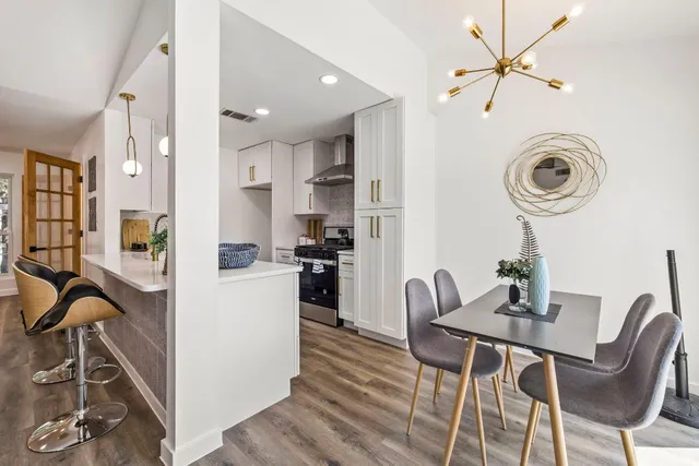 a view of a dining room with furniture and chandelier