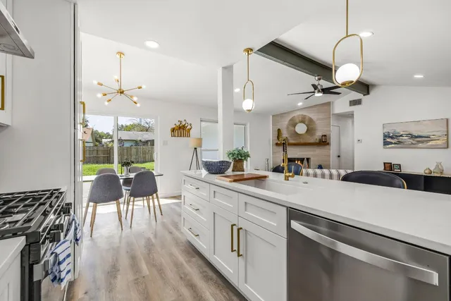 a kitchen with a table chairs stove and wooden floor