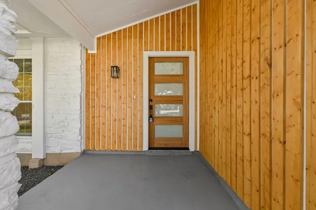a view of a hallway with wooden walls