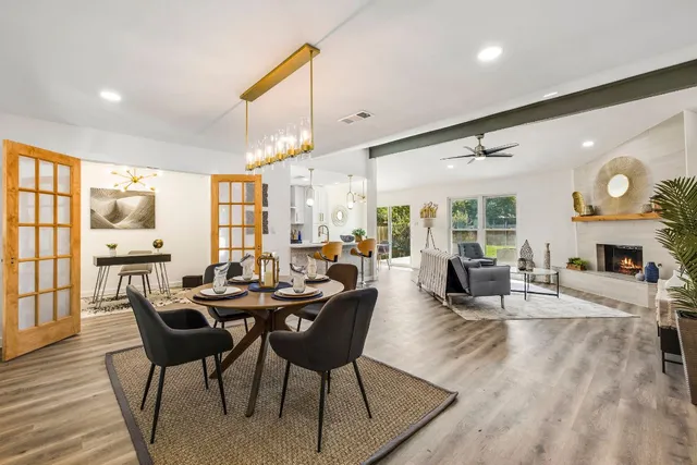 a dining room with furniture a fireplace and wooden floor