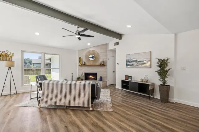 a living room with furniture a fireplace and a flat screen tv