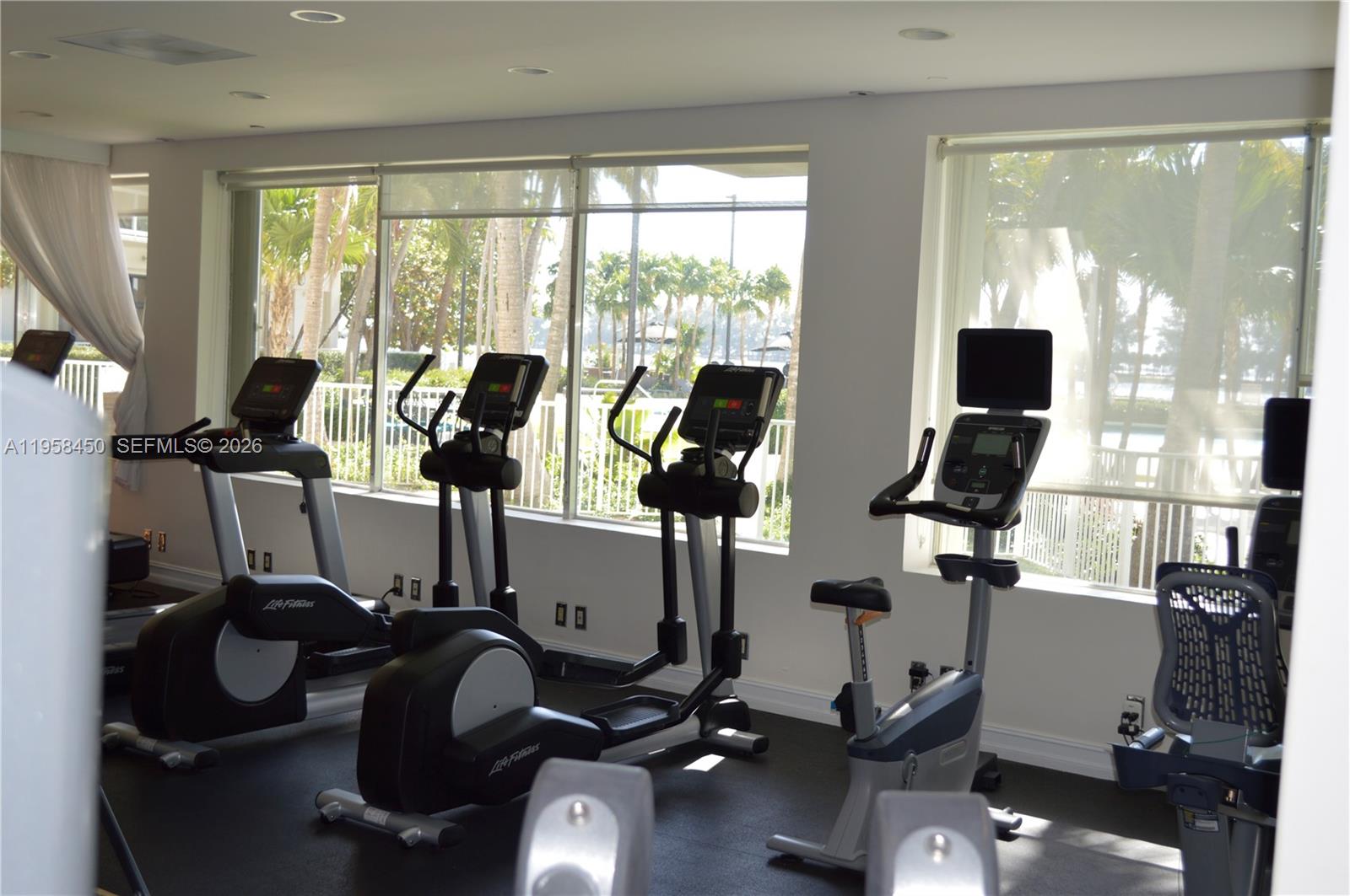 2451 Brickell Avenue, Unit PHM Miami, FL 33129 - Photo 11 of 52 a room with gym equipment and large windows