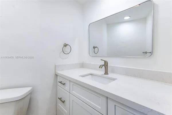 a bathroom with a sink a toilet and a mirror
