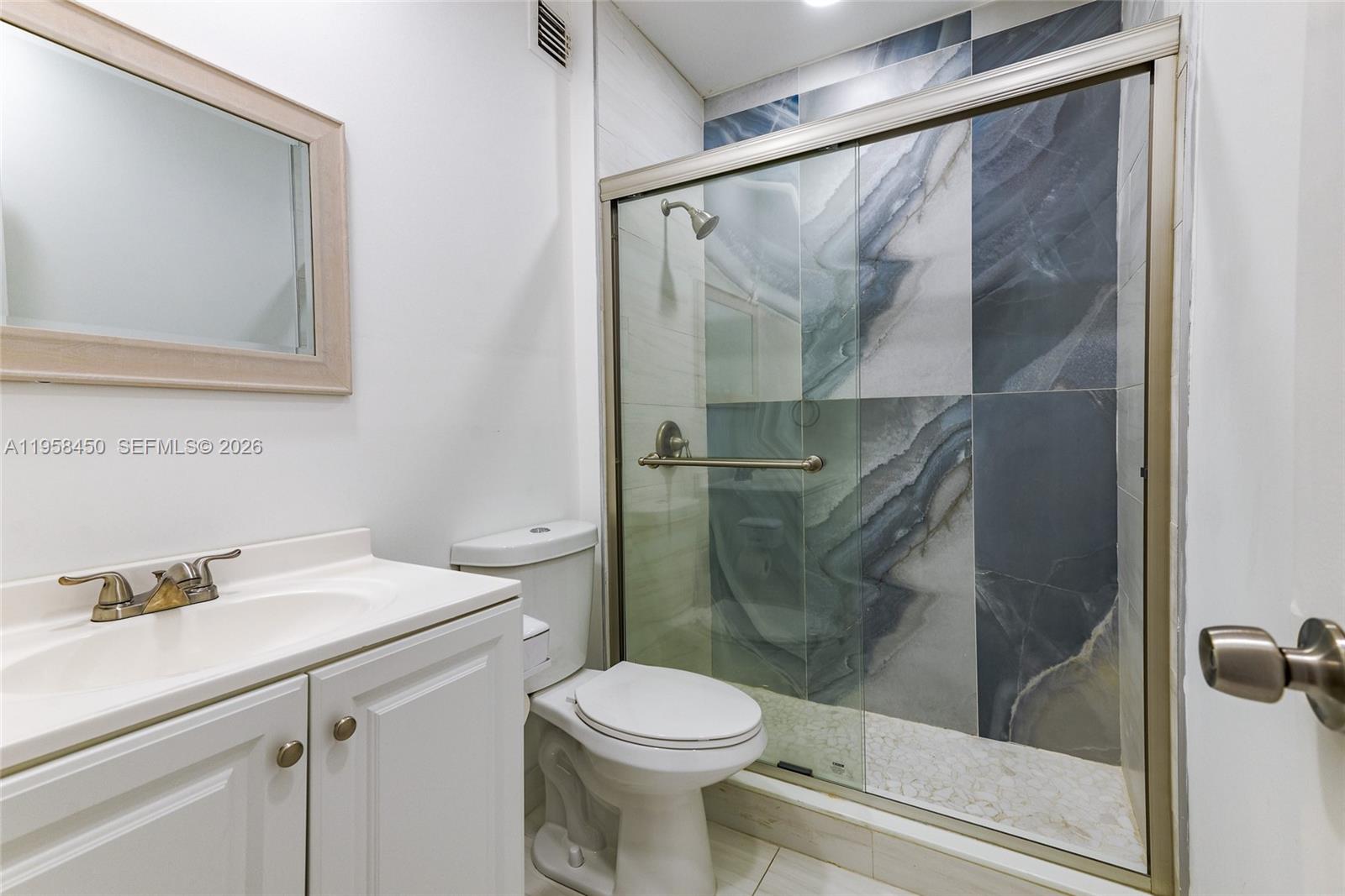 2451 Brickell Avenue, Unit PHM Miami, FL 33129 - Photo 28 of 40 a bathroom with a shower sink vanity and toilet