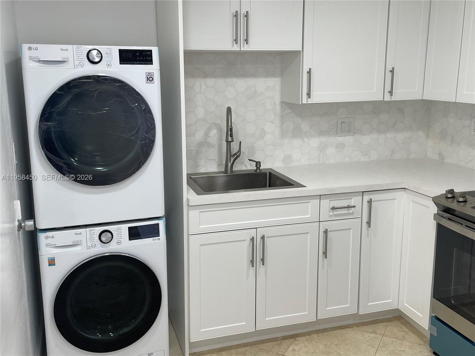 2451 Brickell Avenue, Unit PHM Miami, FL 33129 - Photo 35 of 52 a kitchen with white cabinets and sink