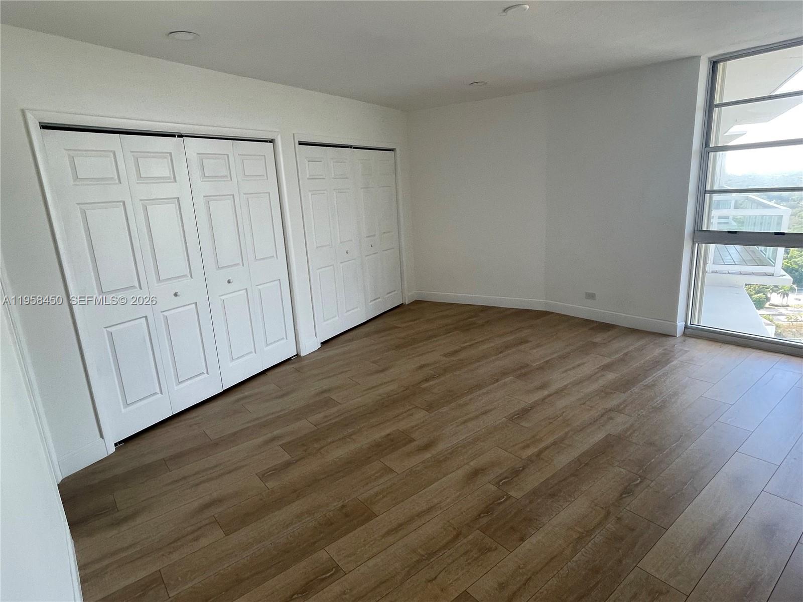 2451 Brickell Avenue, Unit PHM Miami, FL 33129 - Photo 41 of 52 a view of an empty room with wooden floor and a window