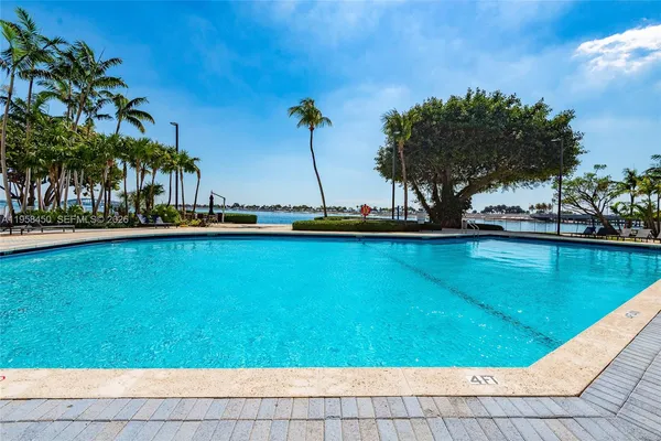 a view of swimming pool with a yard and trees