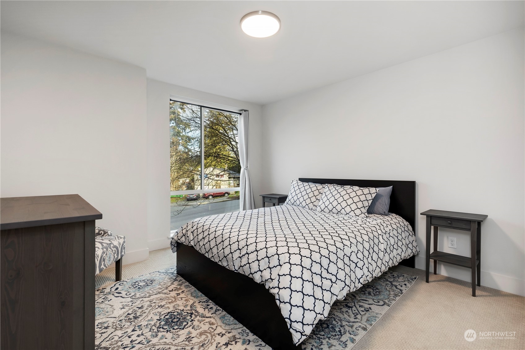 10162 Holman Road Northwest, Unit E Seattle, WA 98133 - Photo 11 of 26 a bedroom with a bed and window