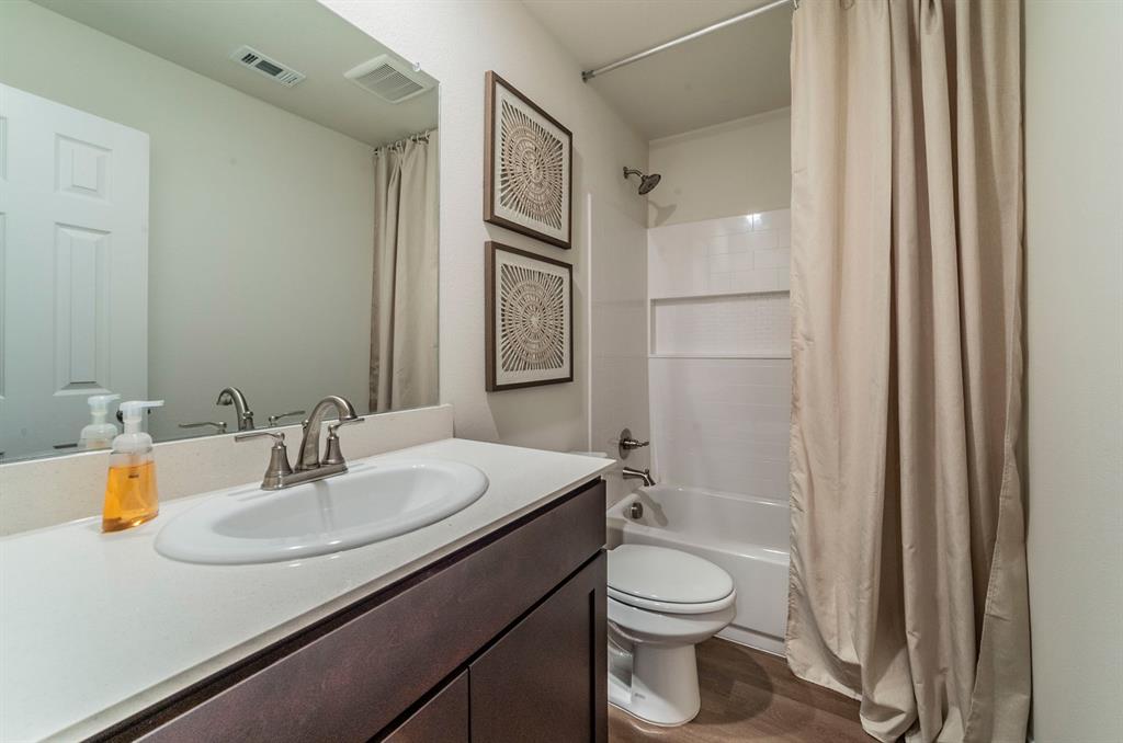 440 Rose Avenue Cleburne, TX 76033 - Photo 12 of 14 a bathroom with a sink a toilet and shower