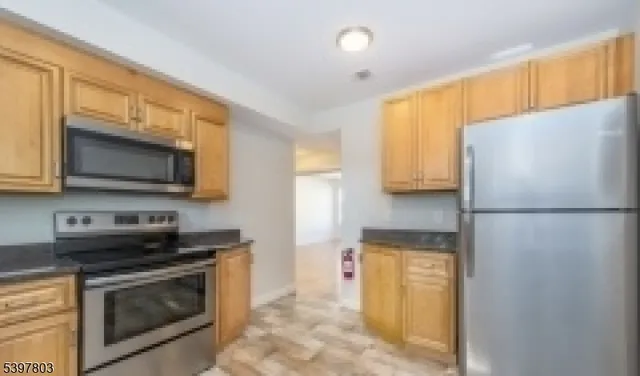 a kitchen with stainless steel appliances a stove a microwave and a refrigerator