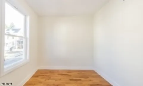 a view of a small space with wooden floor and a window