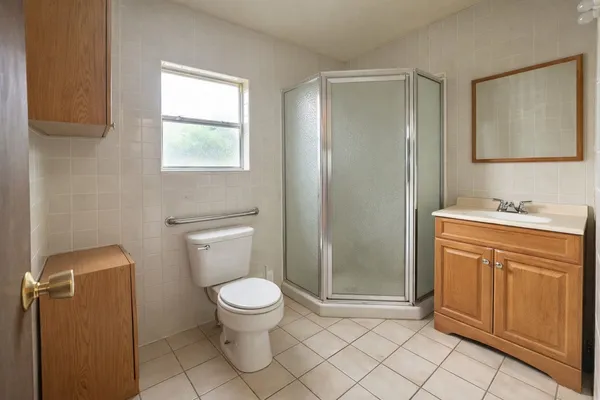 a bathroom with a granite countertop toilet sink and mirror