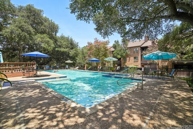 a view of a patio with a table and chairs under an umbrella