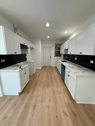 a kitchen with granite countertop a sink a counter top space stainless steel appliances and cabinets
