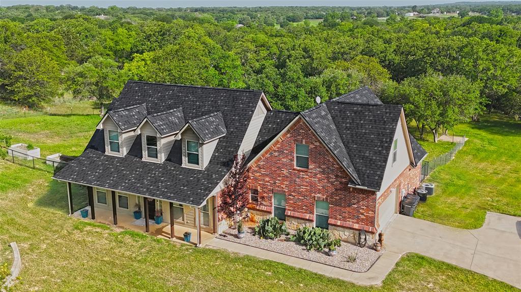 307 Sandpiper Drive Weatherford, TX 76088 - Photo 1 of 1 View of front facade with a forest view, driveway, covered porch, and a front lawn