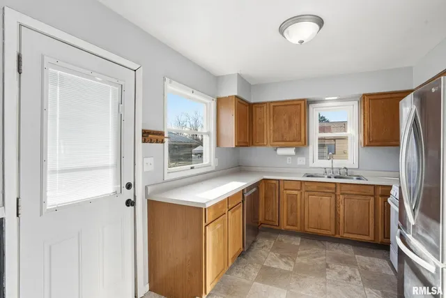 a kitchen with stainless steel appliances granite countertop a sink and a refrigerator