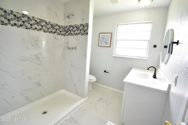 a bathroom with a sink a toilet and shower