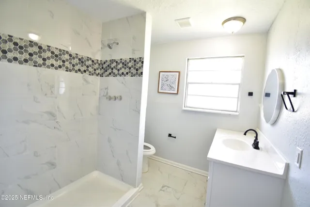 a bathroom with a toilet sink and mirror
