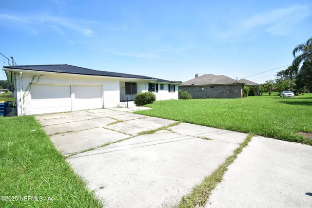 a view of a house with a yard and sitting area