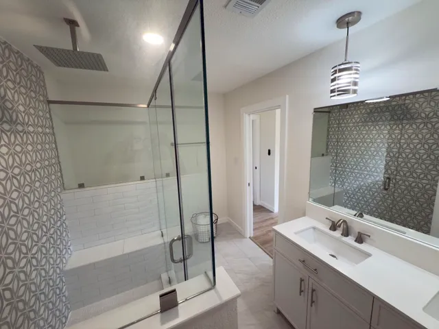 a bathroom with a tub sink shower and a mirror