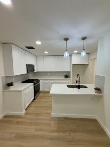 a large kitchen with kitchen island a sink stainless steel appliances and cabinets