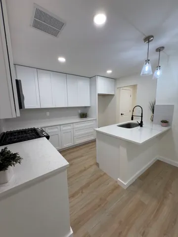 a view of an empty room with wooden floor fireplace and a window
