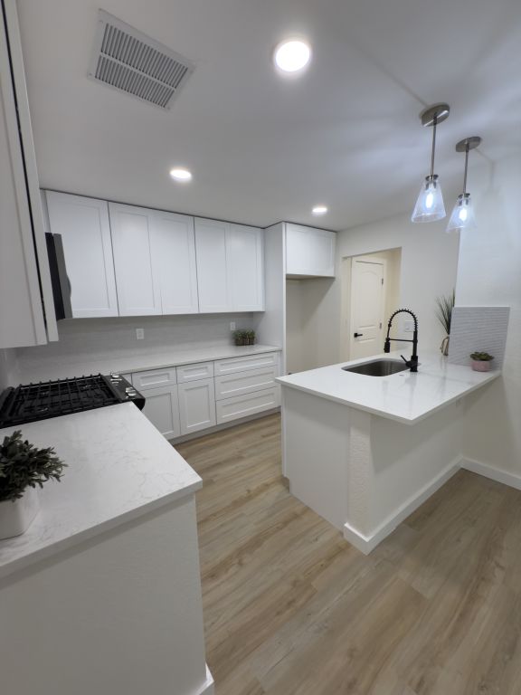 818 Russet Valley Drive Cedar Park, TX 78613 - Photo 5 of 17 Kitchen with a peninsula, white cabinets, light wood-style flooring, recessed lighting, and pendant lighting