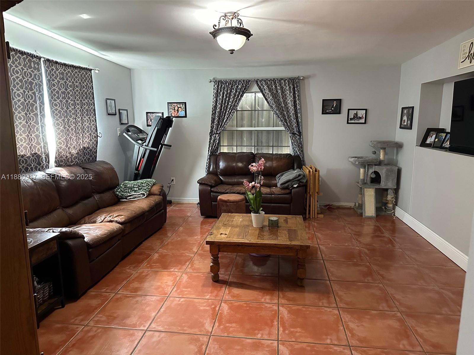 12495 Southwest 240th Street Homestead, FL 33032 - Photo 12 of 26 a living room with furniture a window and a flat screen tv