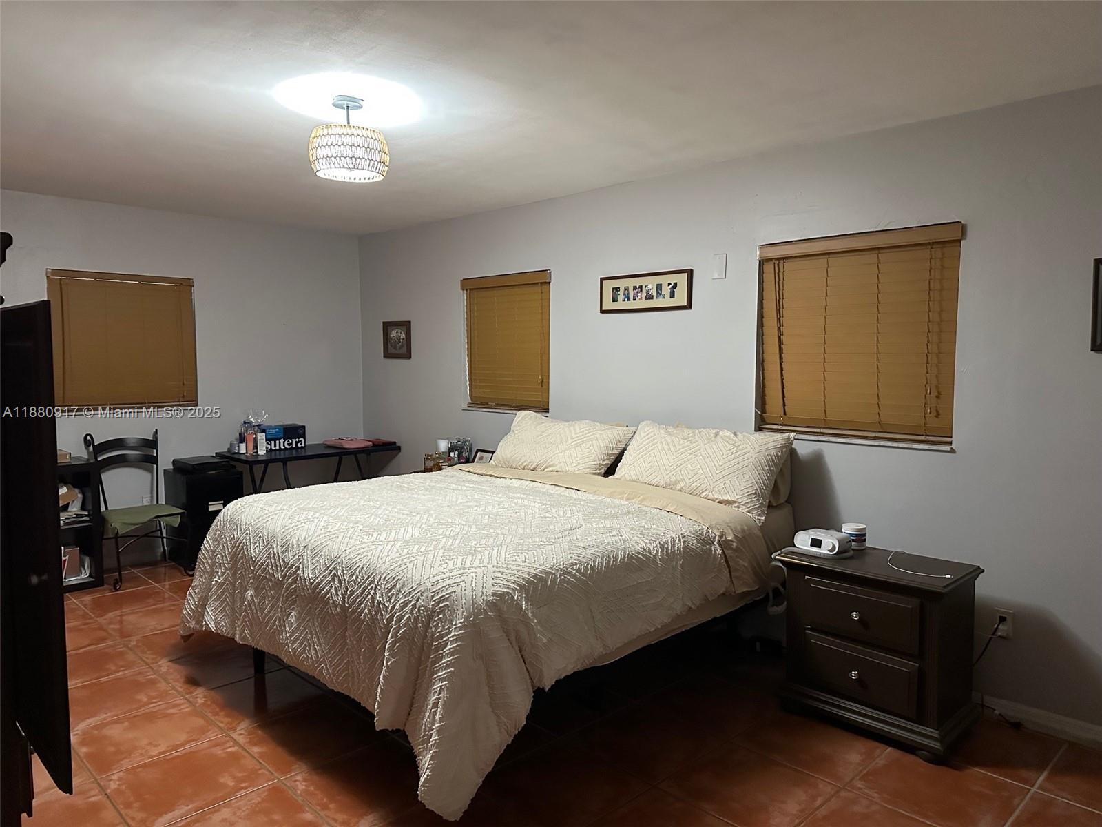 12495 Southwest 240th Street Homestead, FL 33032 - Photo 14 of 26 a bedroom with a bed and a lamp on dresser