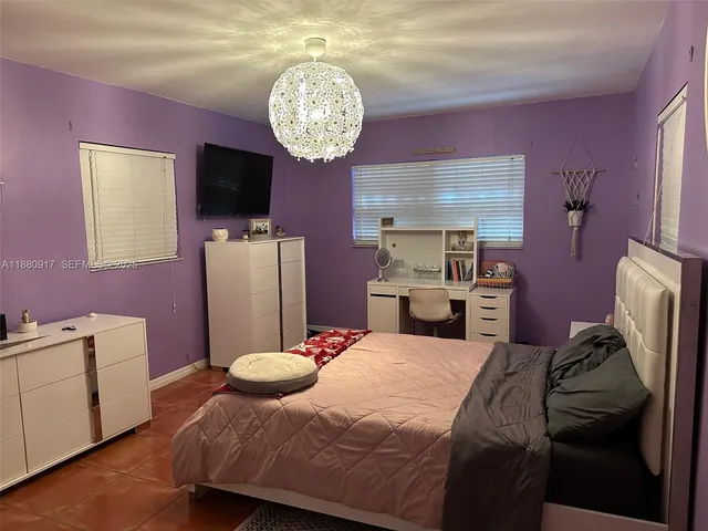 a bedroom with a bed chair and a desk