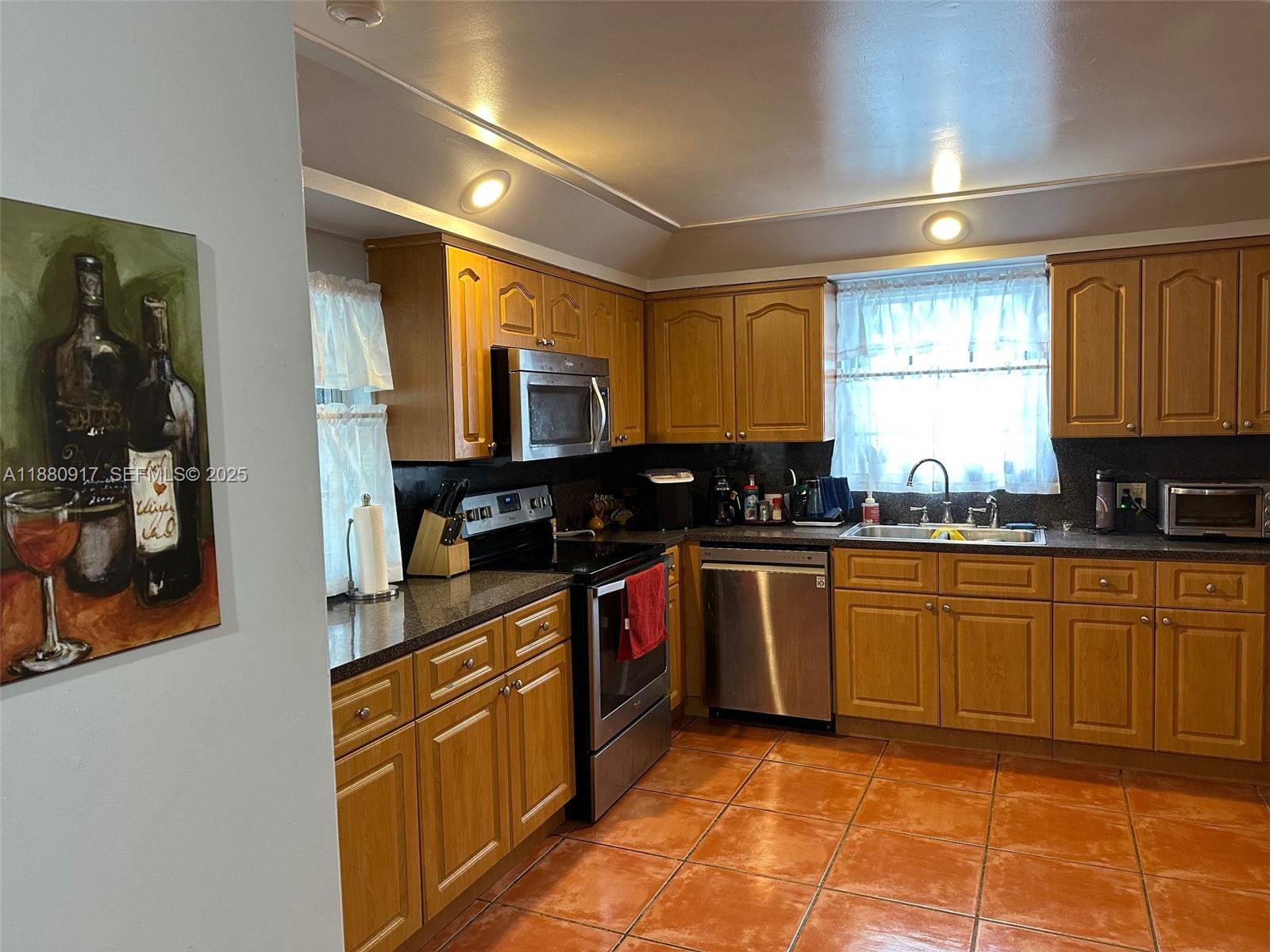 12495 Southwest 240th Street Homestead, FL 33032 - Photo 7 of 26 a kitchen with stainless steel appliances granite countertop a stove a sink and a microwave