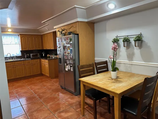 a kitchen with stainless steel appliances granite countertop a refrigerator and a stove top oven