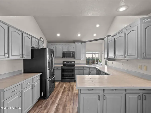 a kitchen with stainless steel appliances granite countertop a refrigerator sink and stove