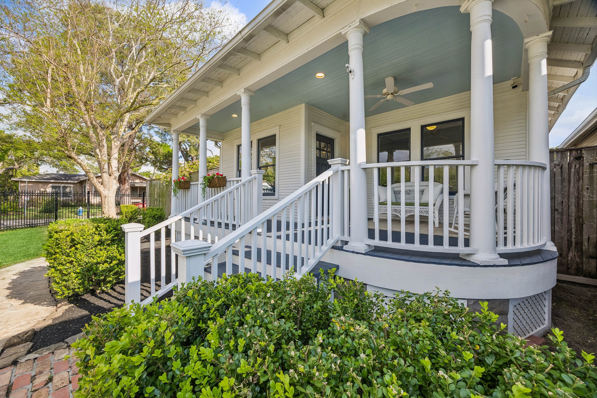 812 West 13th Street Houston, TX 77008 - Photo 28 of 29 Charming home with a welcoming front porch featuring classic columns, a ceiling fan, and cozy seating. Surrounded by lush greenery and a quaint brick pathway, it's perfect for relaxing outdoors.