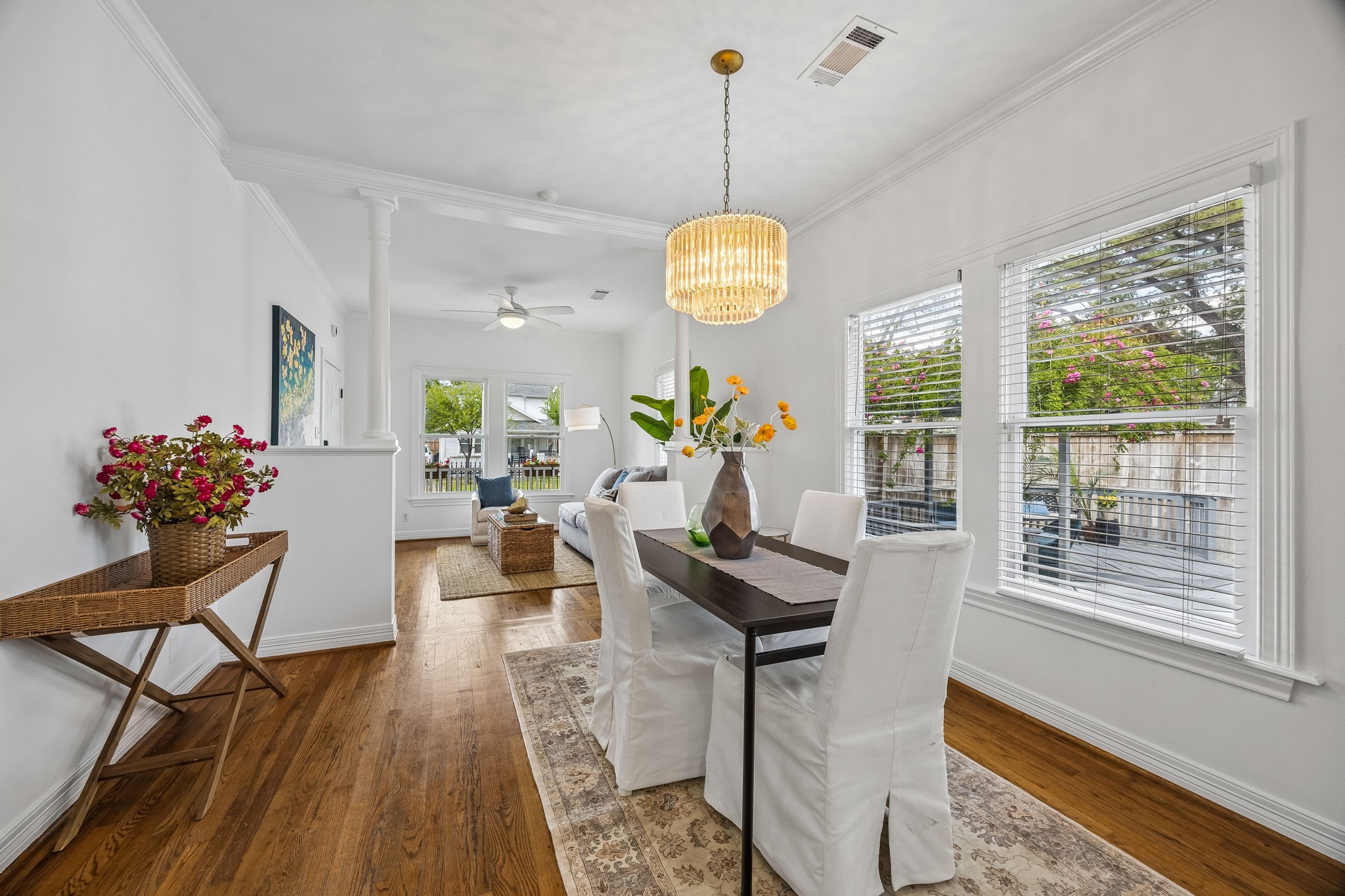 812 West 13th Street Houston, TX 77008 - Photo 3 of 29 Bright and inviting open-plan living and dining area with hardwood floors, large windows, and elegant light fixtures. The space features a cozy seating area and a stylish dining table, perfect for entertaining and relaxation.