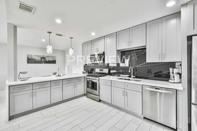 a kitchen with white cabinets stainless steel appliances and sink