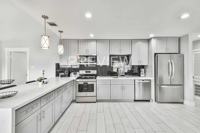 a kitchen with white cabinets stainless steel appliances and sink