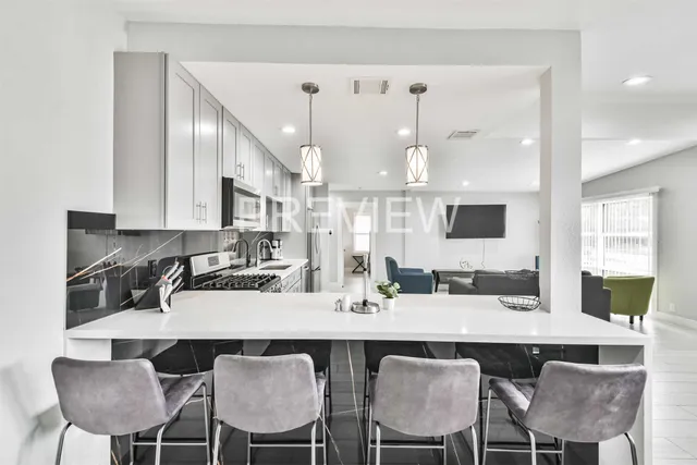 a kitchen with a dining table chairs and large window