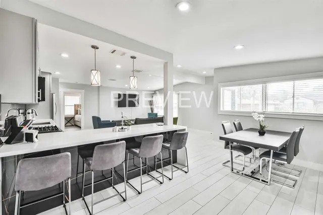 a room with stainless steel appliances a table and chairs in it