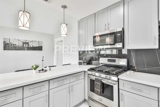 a kitchen with granite countertop cabinets stainless steel appliances and wooden floor