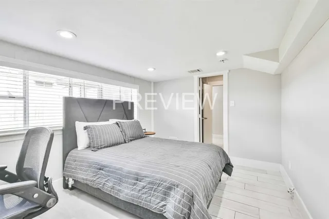 a bedroom with a large bed and chair