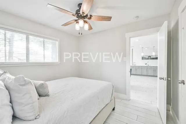 a bedroom with a large bed and a chandelier