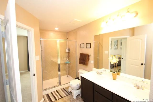 a bathroom with a double vanity sink toilet and shower