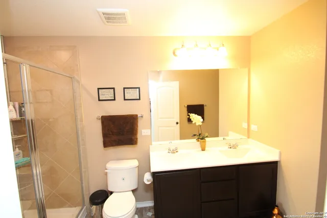 a bathroom with a sink mirror and toilet