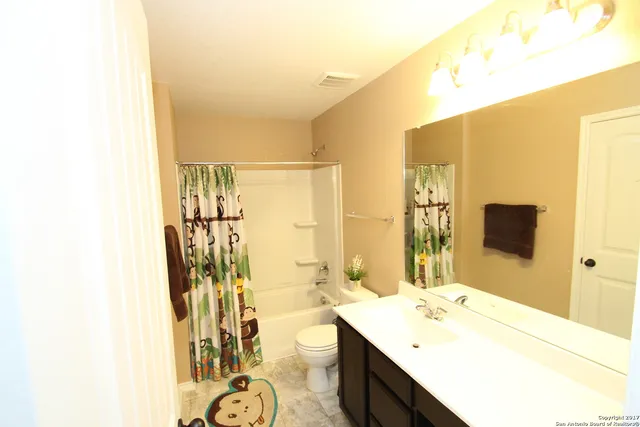 a bathroom with a granite countertop sink a mirror and a shower