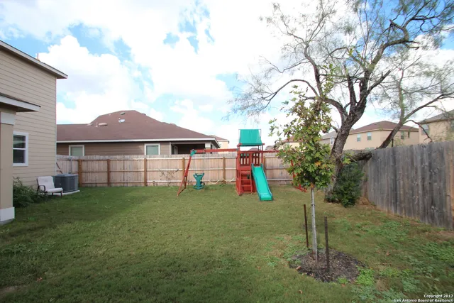 a backyard of a house with table and chairs