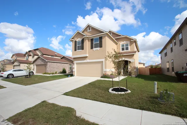 a view of a white house next to a yard