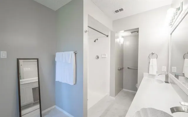 a bed sitting in a spacious bedroom next to a window