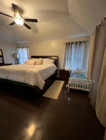 a bedroom with a large bed and a ceiling fan