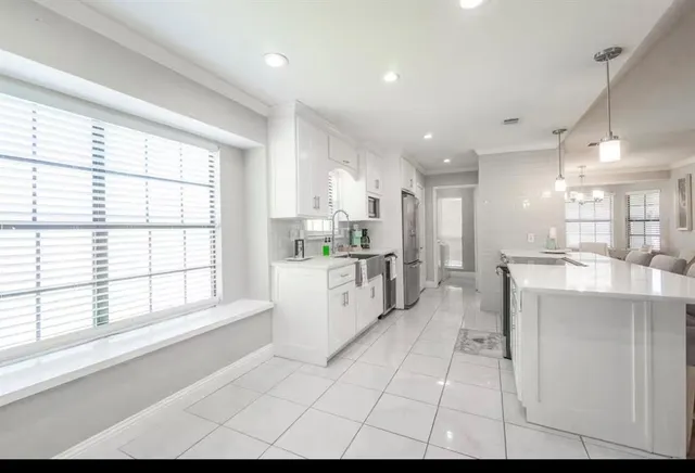 a large white kitchen with a large window